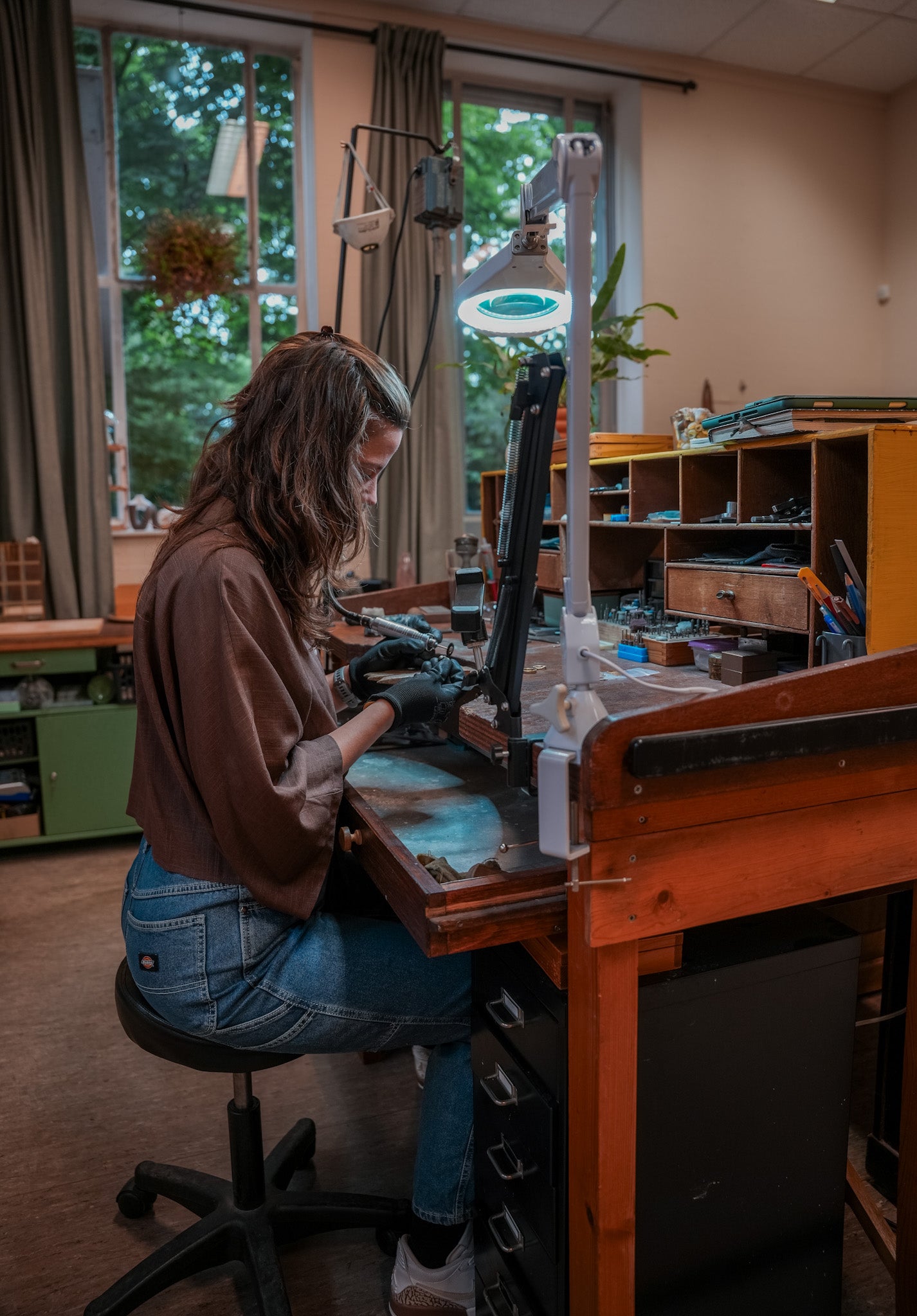 Atelier minne foto werkend aan de werkbank